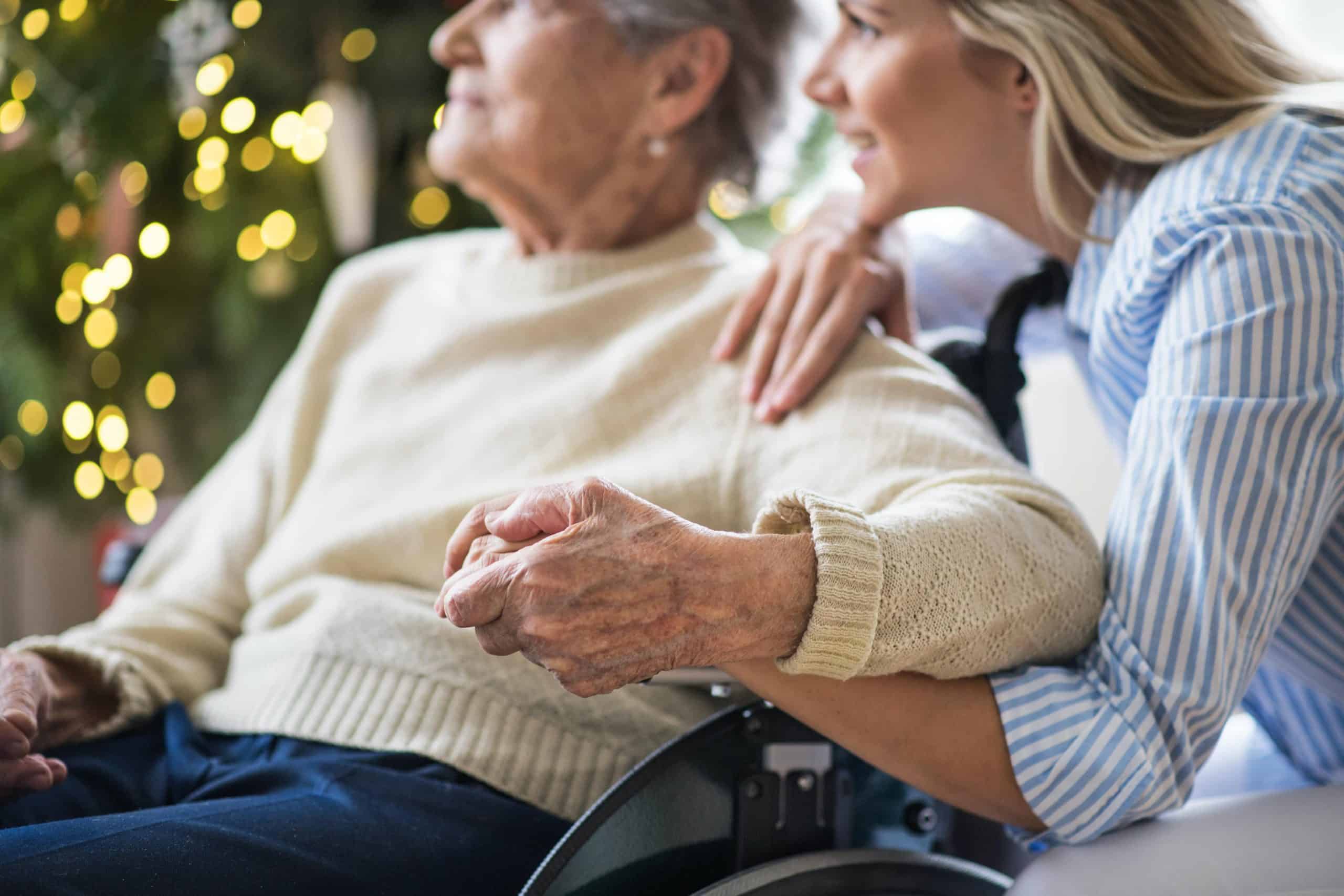 older person holding a younger person's hand for assisted living